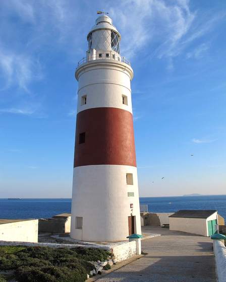 Red-and-white Europa Point lighthouse against a blue sky